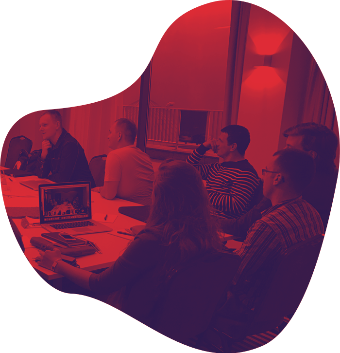 Stylized image of a group of people engaged in a discussion around a table in a meeting room, with a red overlay and an abstract blob-shaped design.