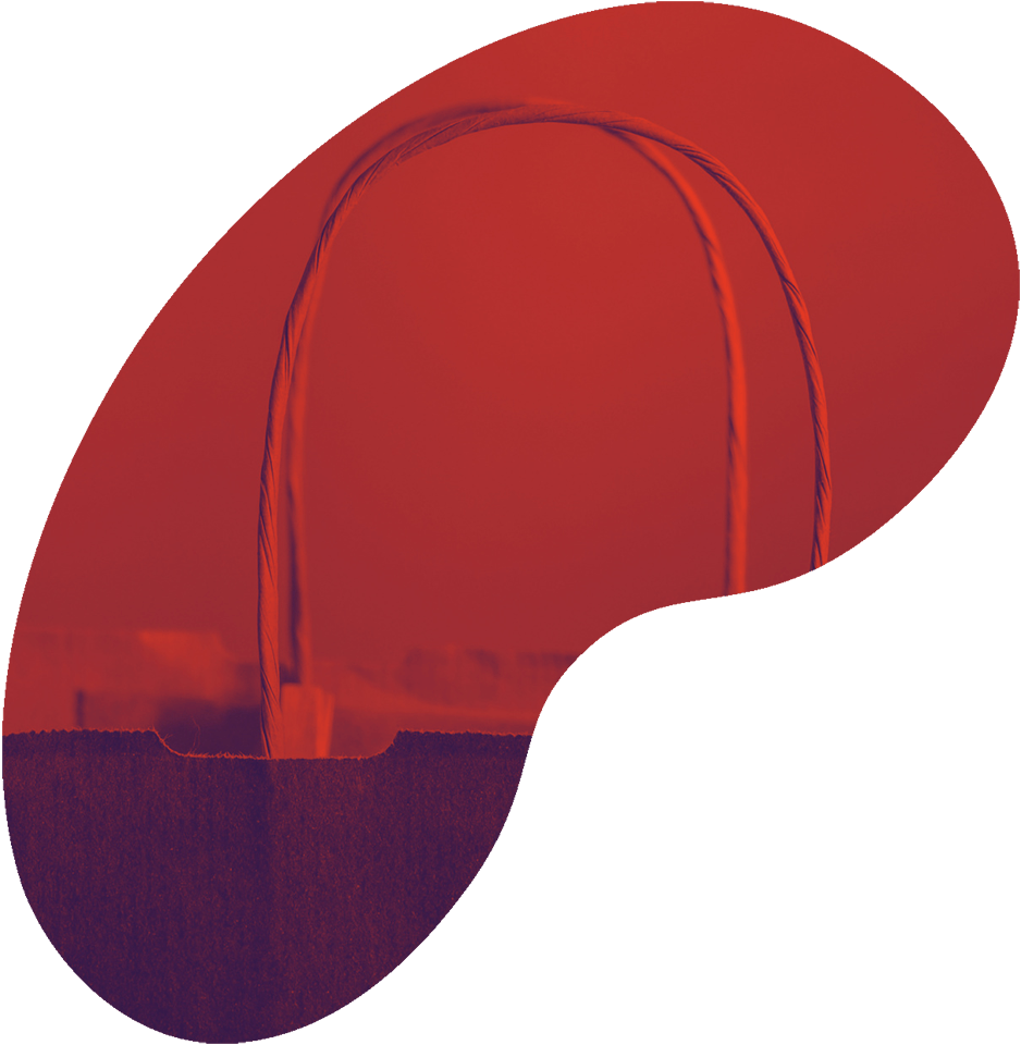 A close-up of a paper shopping bag with twisted handles. The background is blurred, and the image has been edited with a red and dark filter, giving it a stylized appearance.